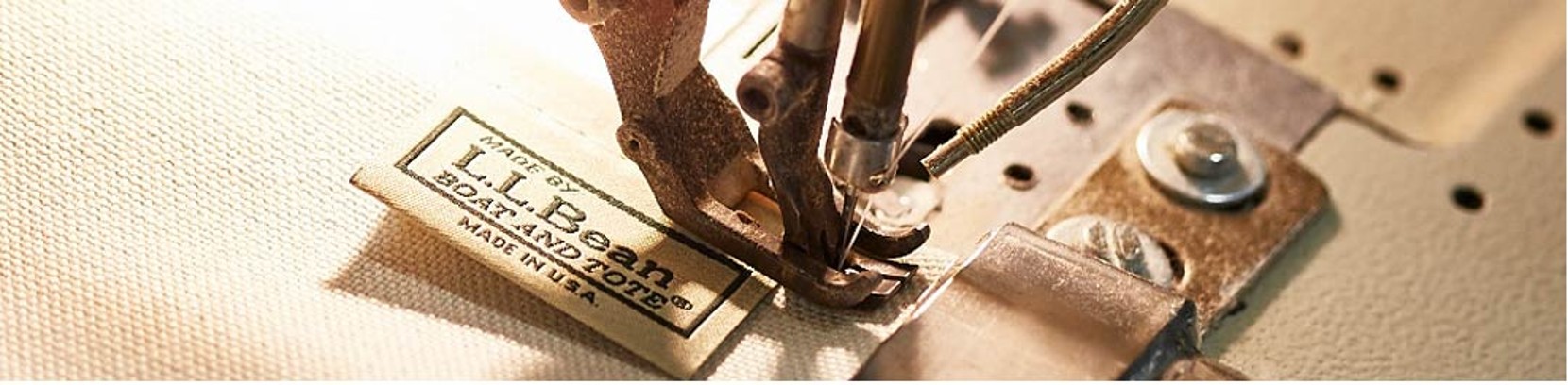 Close up of a sewing machine sewing a Boat and Tote label.