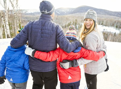 A family dressed in L.L. Bean winter jackets walking in the snow.