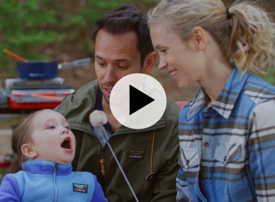 Child with mom and dad eating a toasted marshmallow.