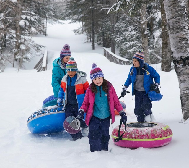 4 kids climbing a sledding hill