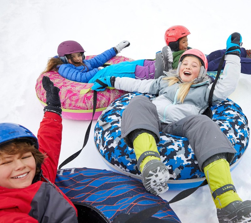 4 laughing kids sledding on Sonic Snow Tubes