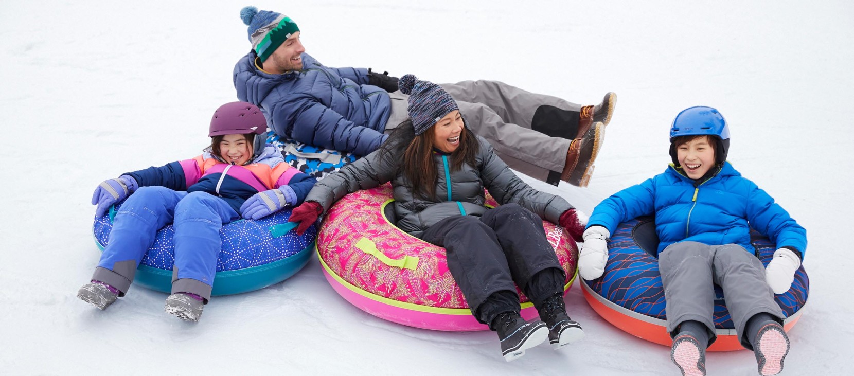 Smiling family of 4 on Sonic Snow Tubes.