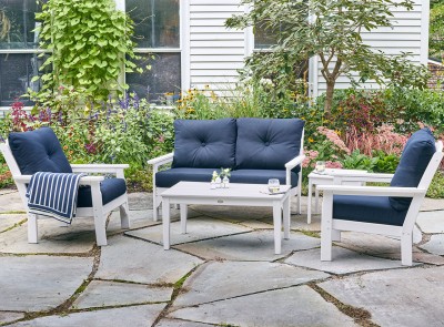 Lush green outdoor patio with 2 L.L. Bean All Weather chairs, a setee and table.
