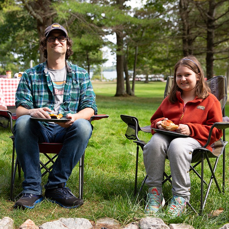 Father and daughter enjoying their meal outside.