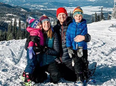 The Bowman family, smiling outside on snowshoes in a beautiful mountain setting.