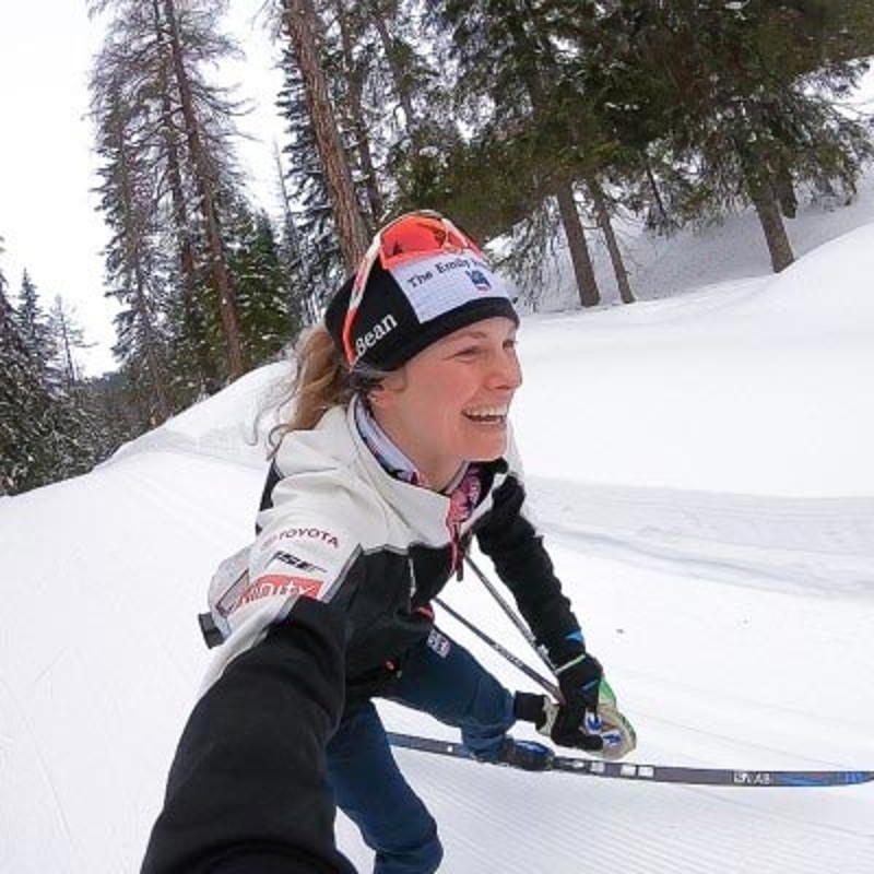 Jessie Diggins smiling and skiing.