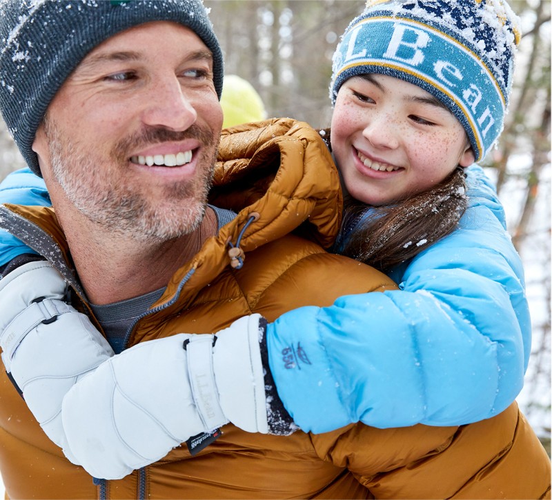 Close-up of Dad giving daughter a piggy-back outside in winter.