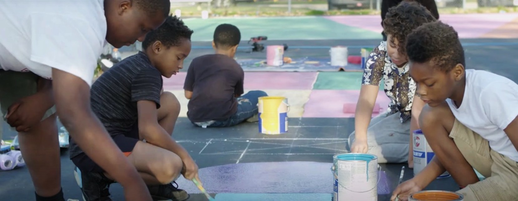 Children outdoors painting on a playground.