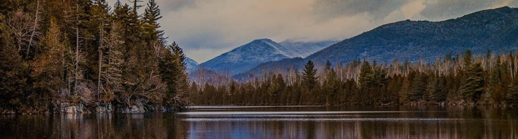 Mountain scenic with lake and evergreen trees.