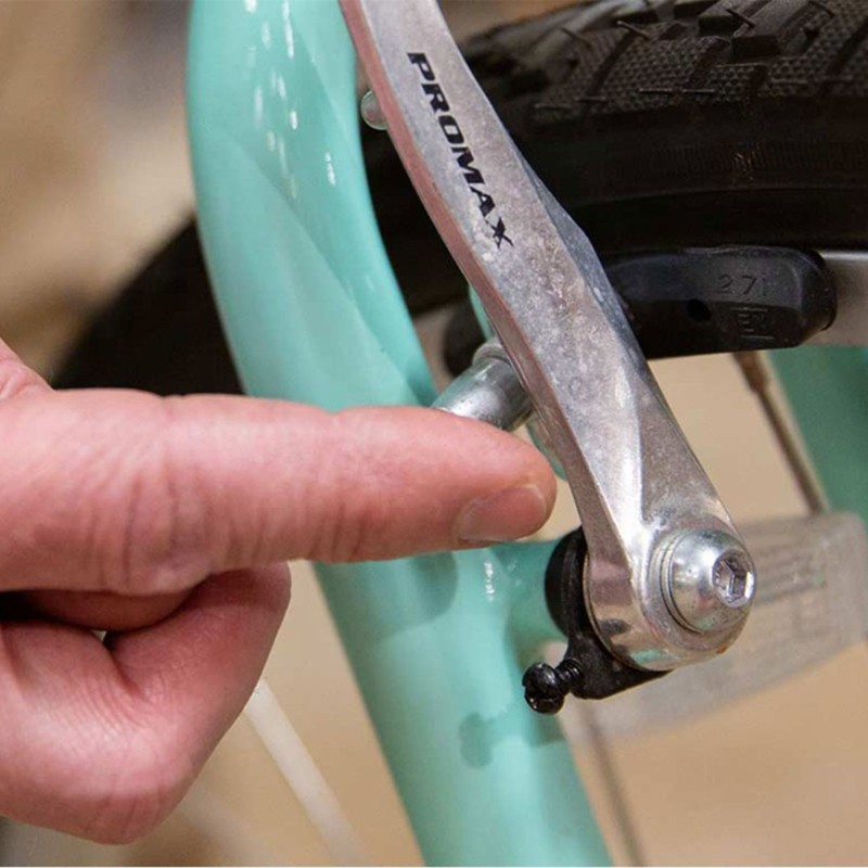 Close-up of a hand making an adjustment to bike breaks.