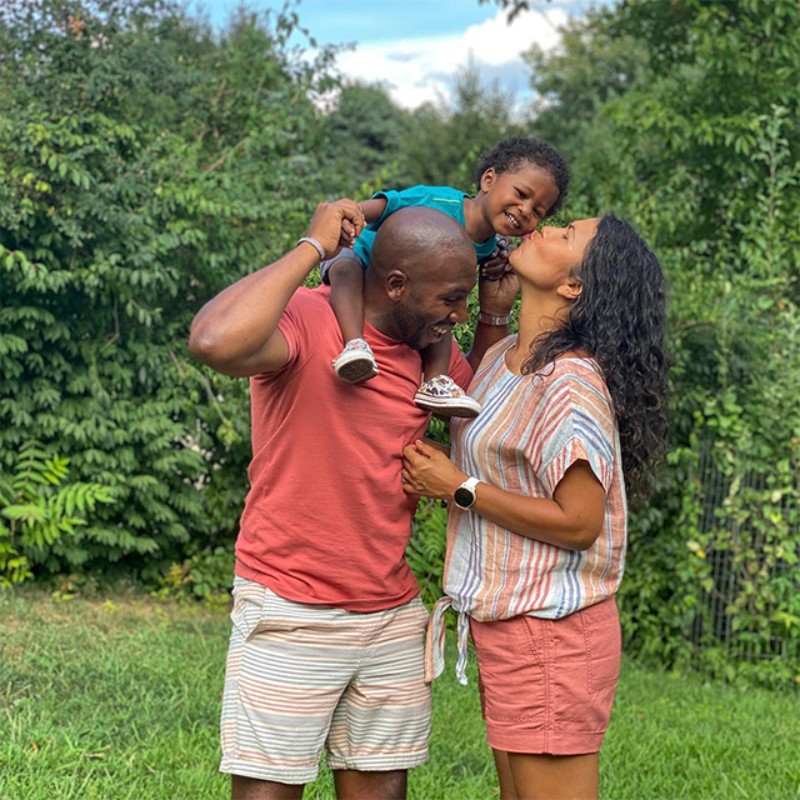 Troy Brooks and family standing next to a lake looking at the foliage.