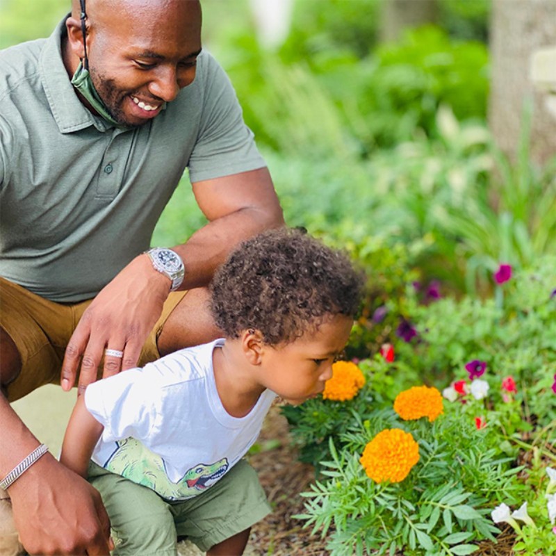 Troy Books and son Avery, smelling flowers.