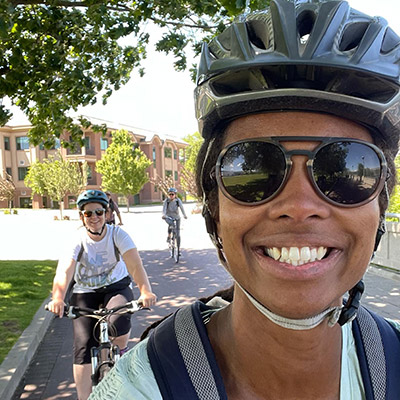 Photo of a woman smiling and riding her bike.