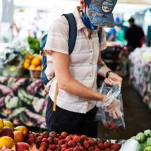 A man shopping at an outdoor farmers market.