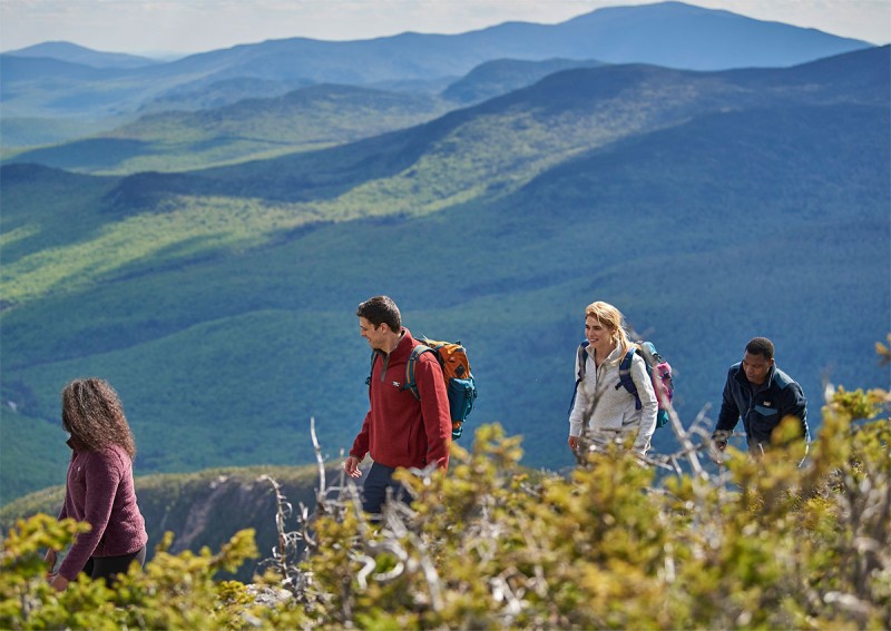 4 friends hiking through a beautiful mountain scene.