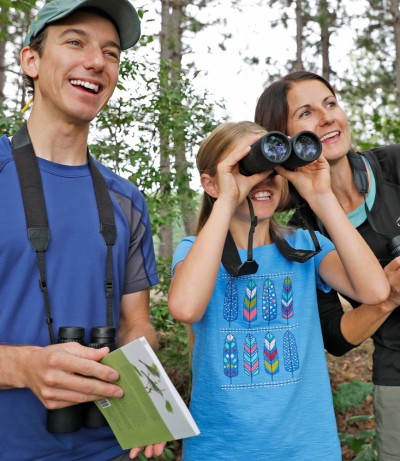 Mom and dad bird watching with their daughter