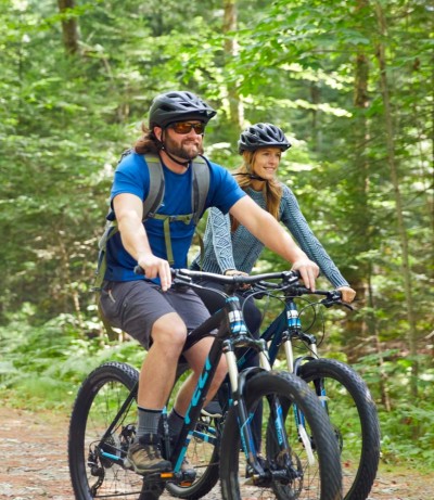 Two people moutain biking in the woods
