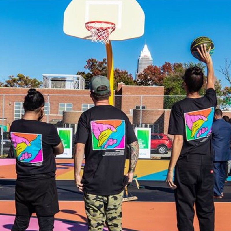 People gathered on an outdoor basketball court.