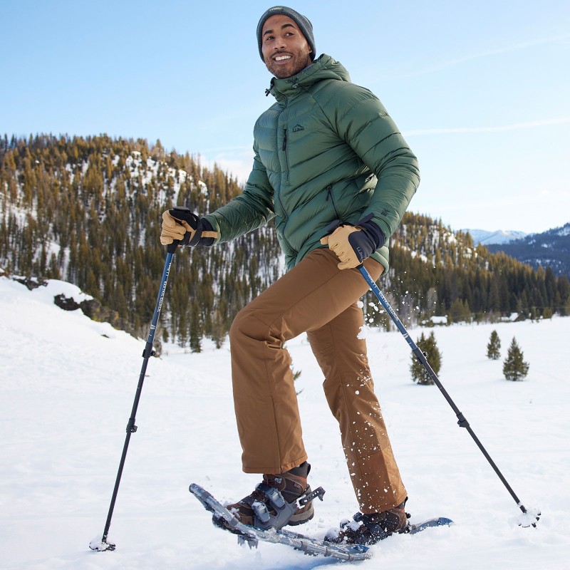 A man snowshoes with hiking poles