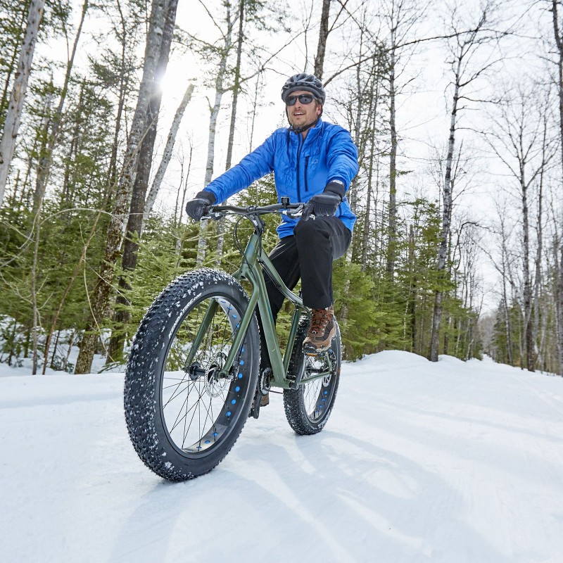 A person out for a fat bike ride on a snowy trail.