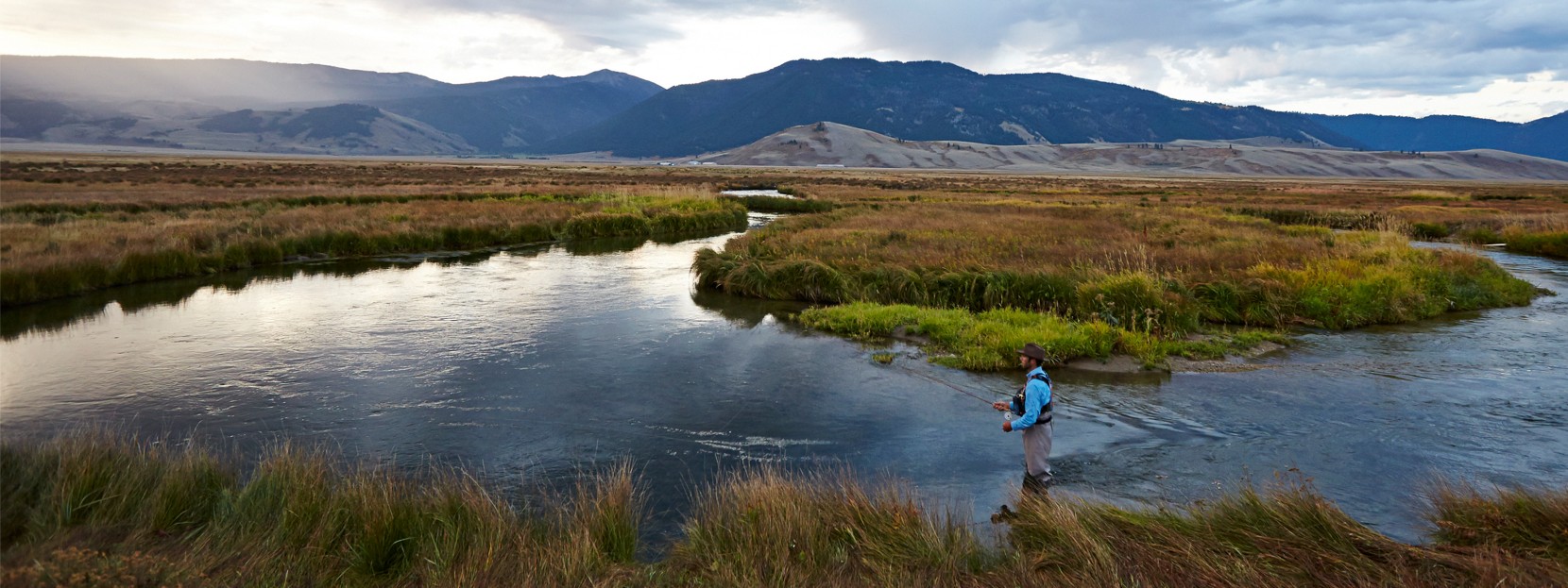 Man standing in a river fishing