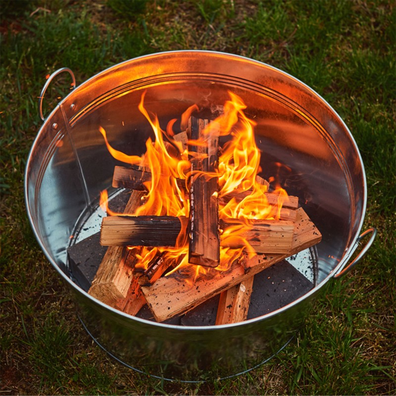 A metal bucket with burning wood.