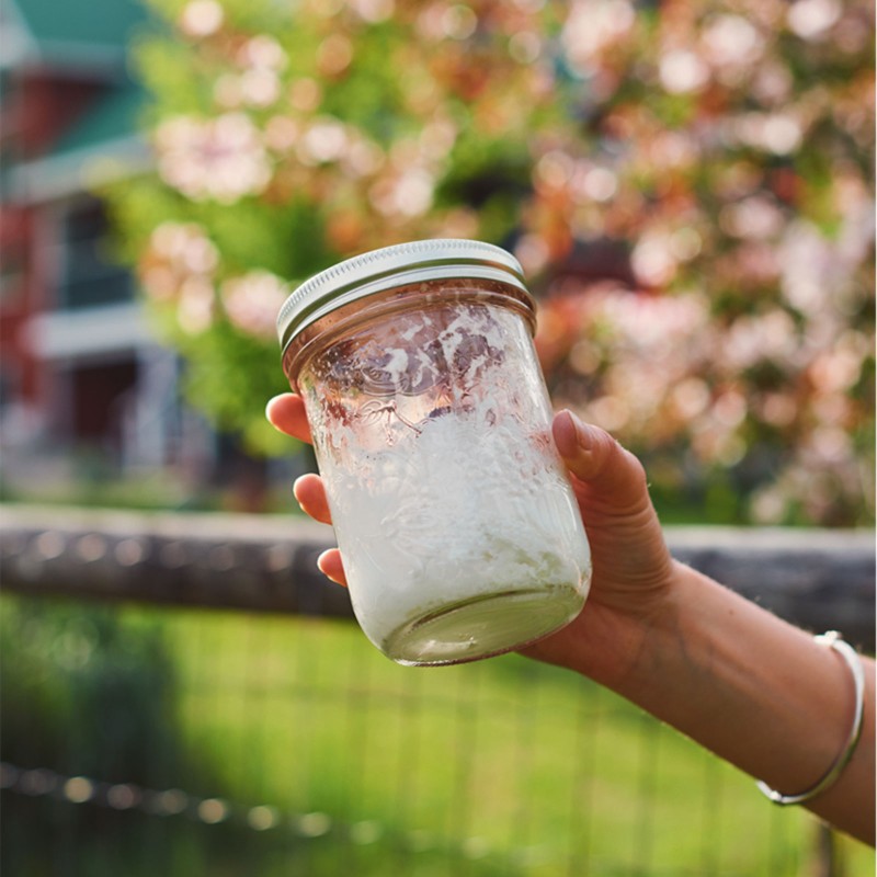 Someone holding a mason jar of partially "whipped" cream.