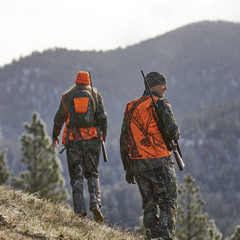 Two hunters walking on a hillside, surveying the area.