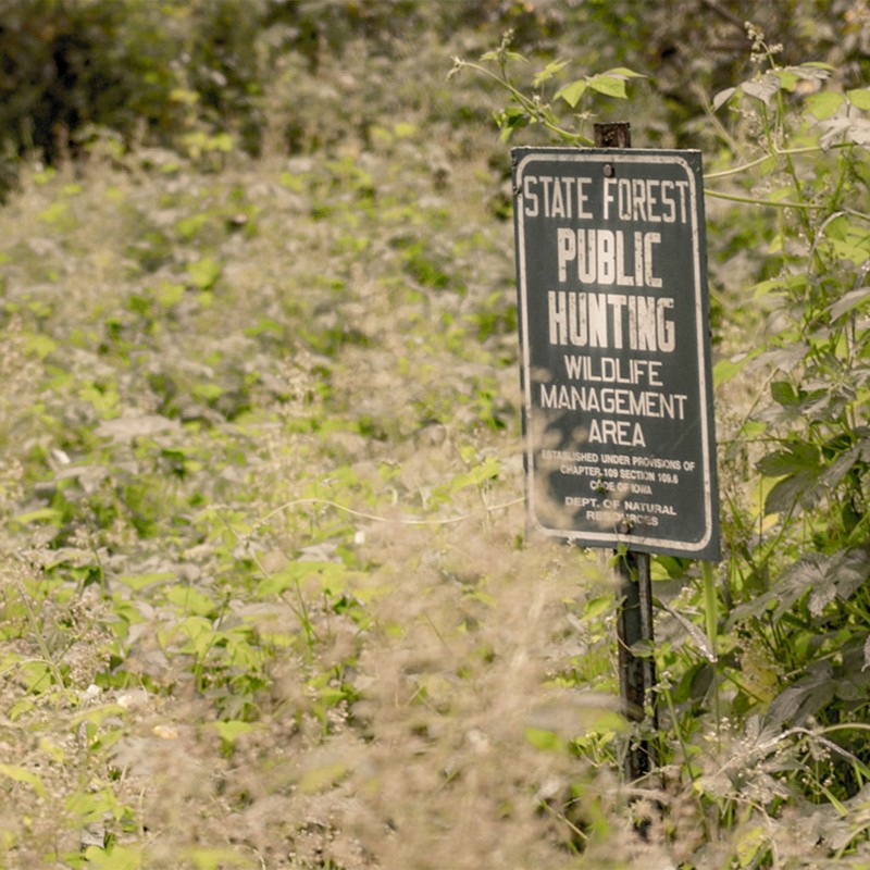 Public hunting sign in a field.