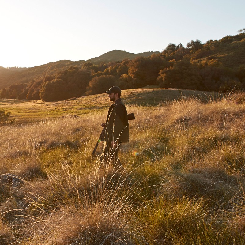 A hunter standing in a field.