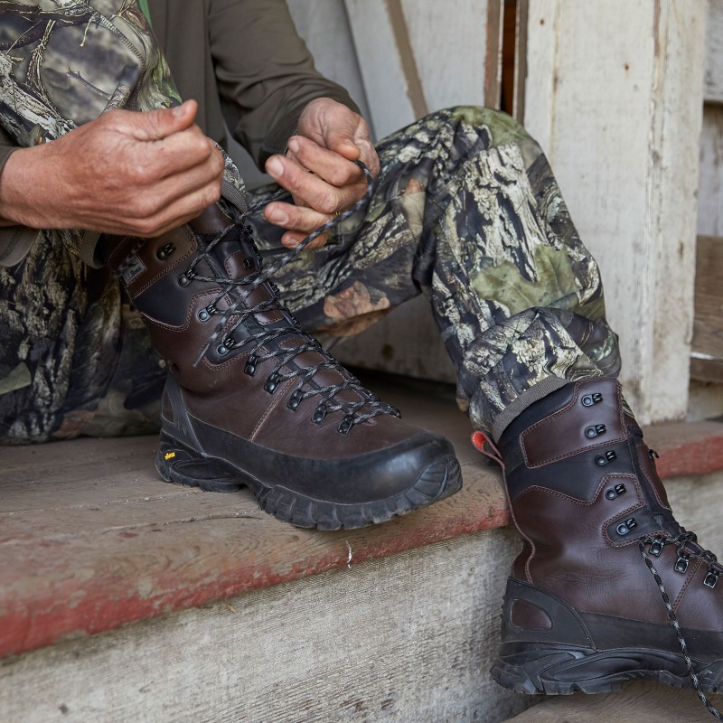 A hunter lacing up his boots.