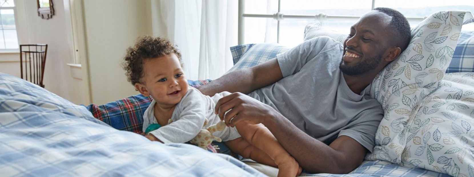 Father and baby relaxing on a cozy bed.