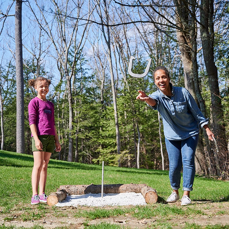 Mom and daughter playing horseshoes.