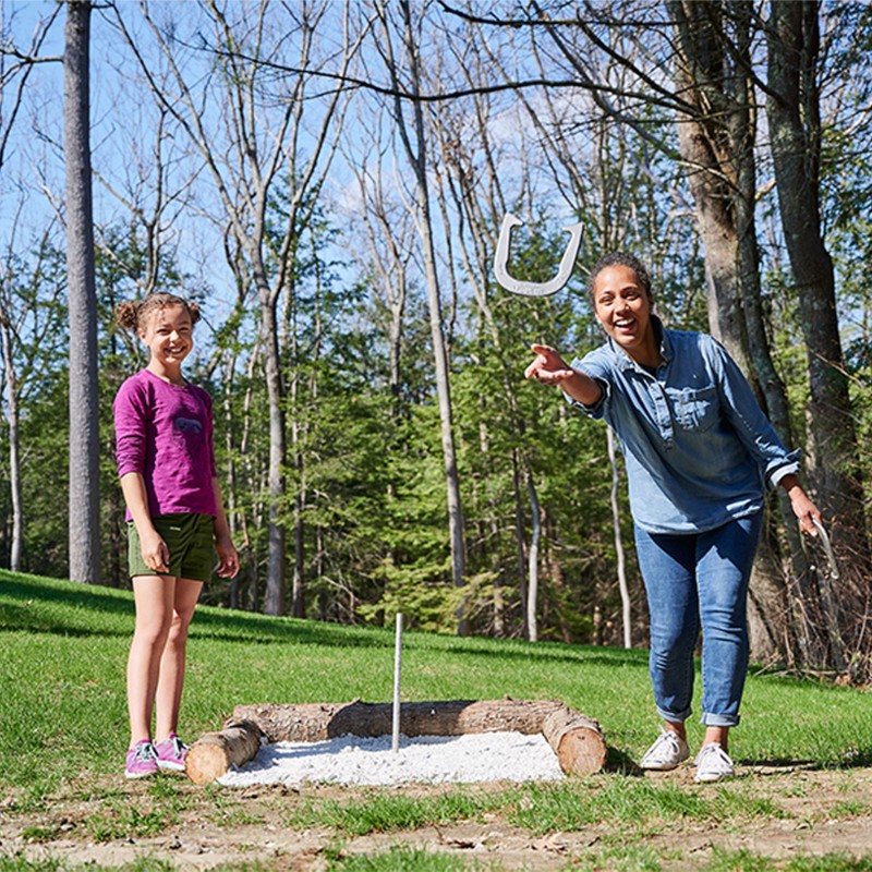 Mom and daughter playing horseshoes.