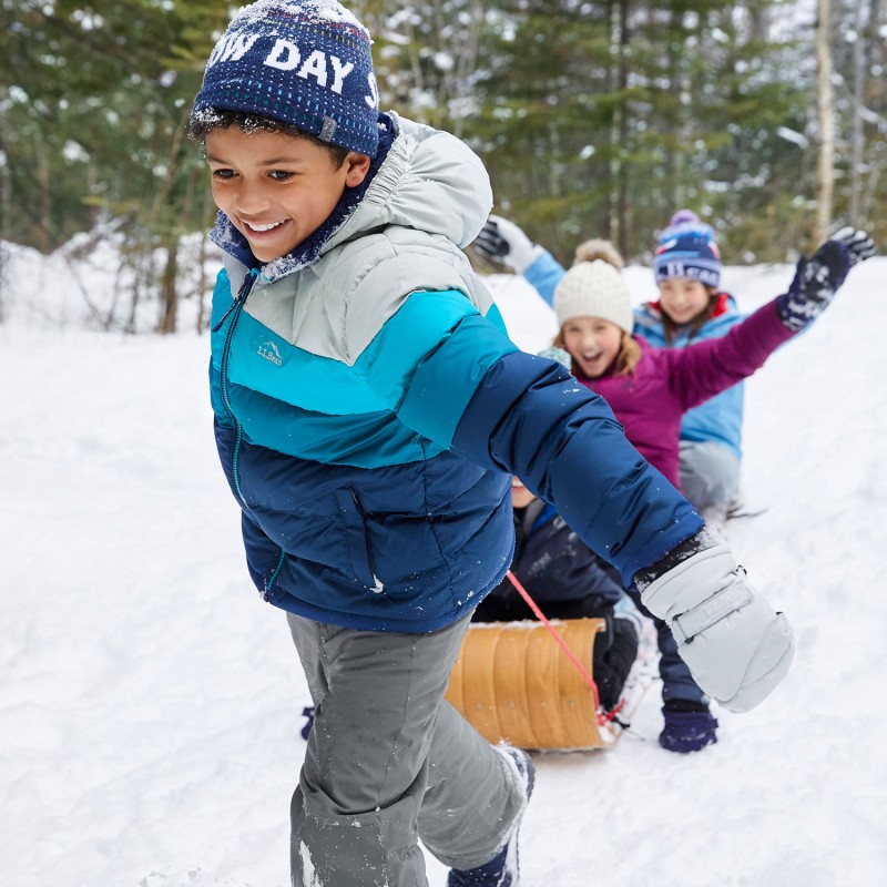 A child pulling other children on a toboggan