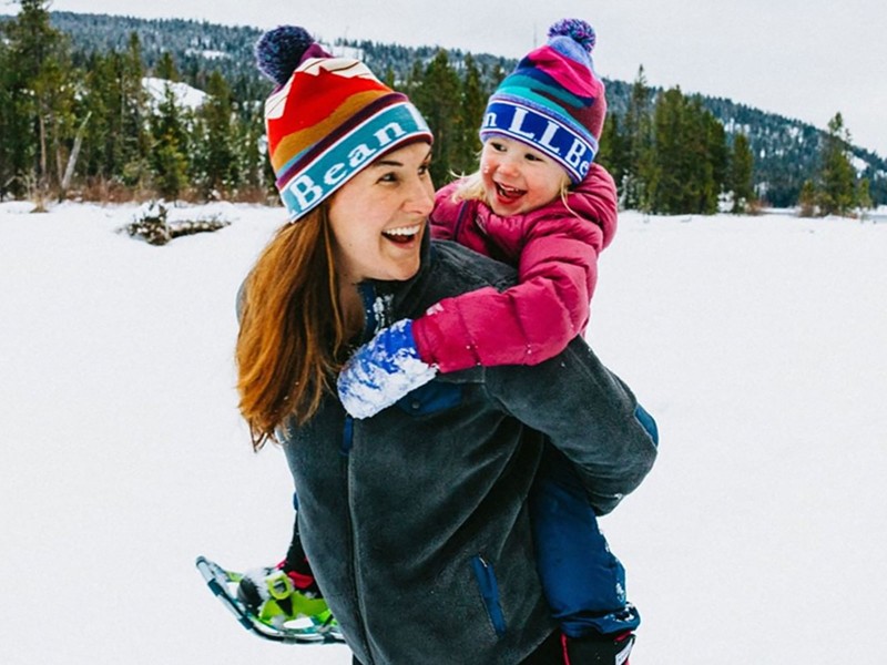 Madison Bowman carrying one of her children on her back outside in the snow