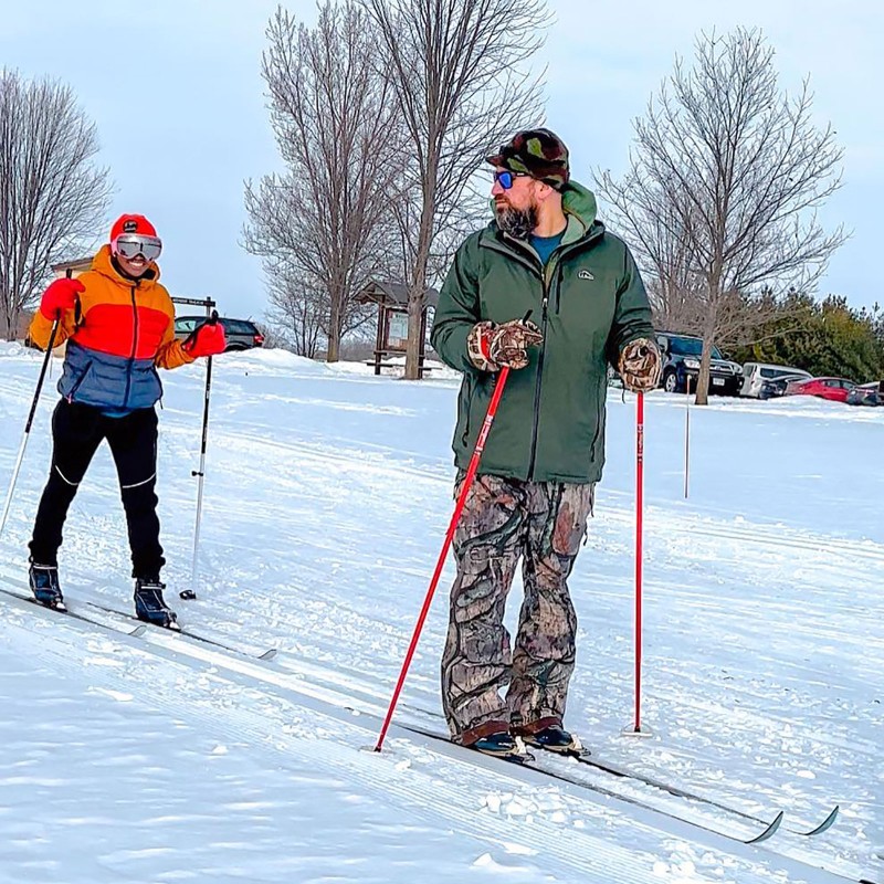 A couple learing to cross country ski.