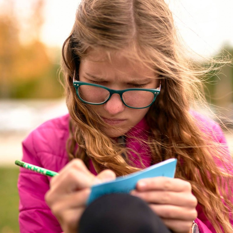 Girl recording weather in notebook