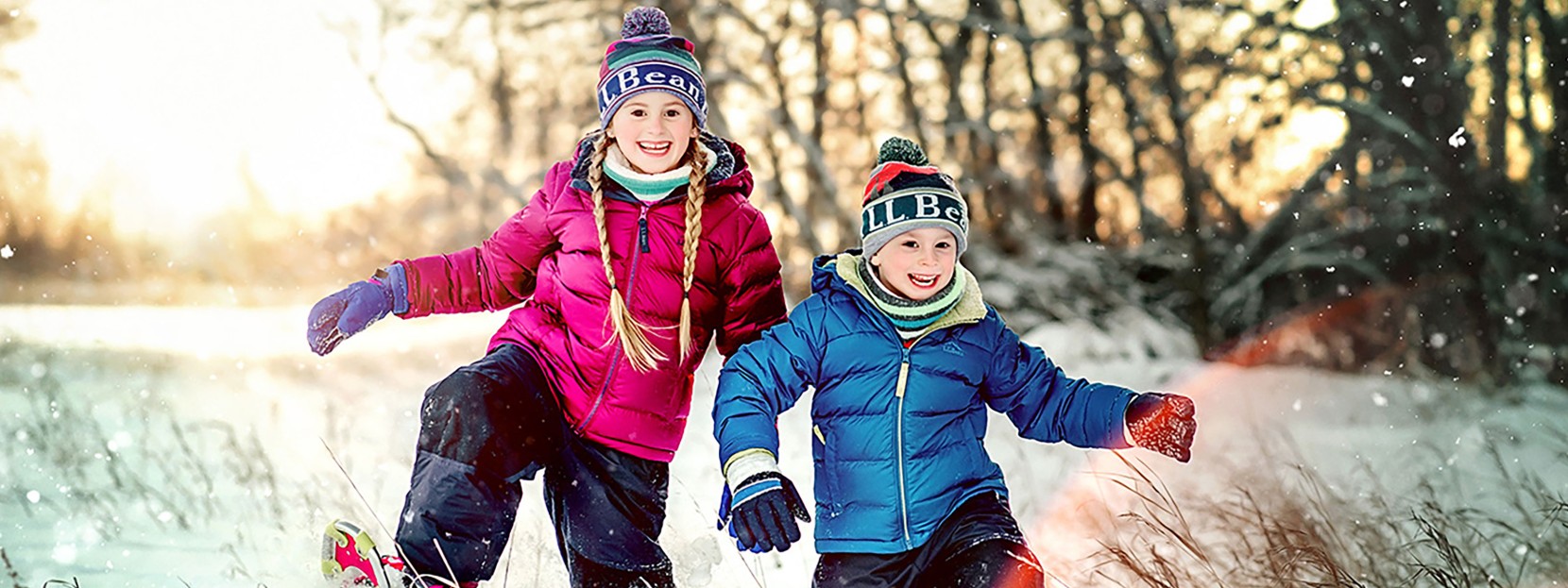 2 happy kids snowshoeing in a field