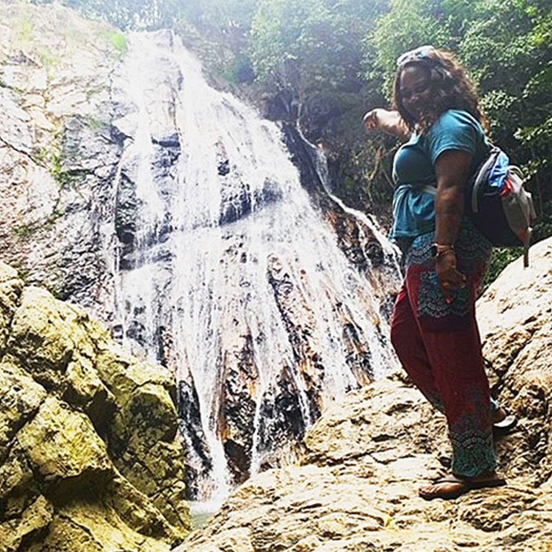 Nicole R. pointing to a waterfall.