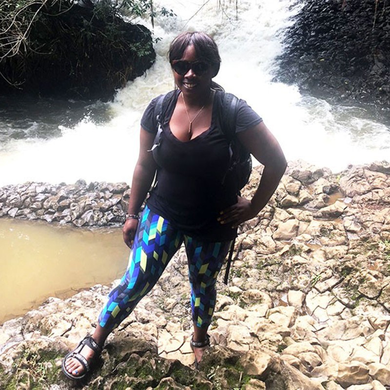 Nicole R. wearing a backpack standing by a river in Wai'anapanapa State Park, Maui.