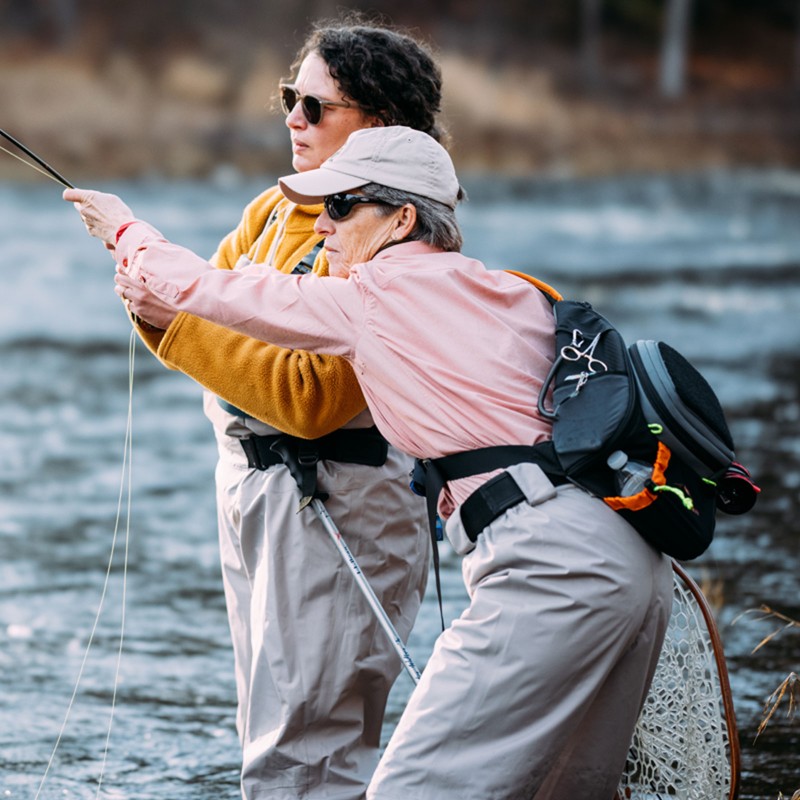 Julie M. being coached by her fly-fishing instructor, Sue.