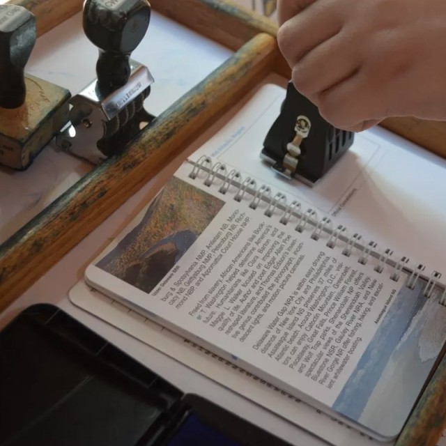 A park book being stamped to commemorate a national park visit.