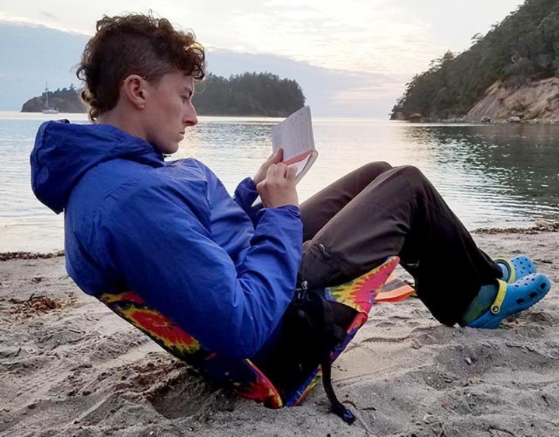 Someone relaxing in a camp chair on the beach.