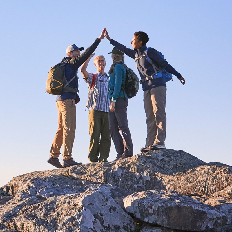 A group of hikers at the top of a mountain.