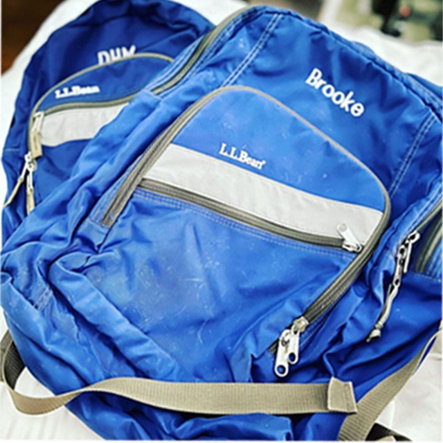 Two blue monogrammed backpacks.