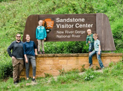 The Bowman Family standing around the Sandstone Visitor Center sign.