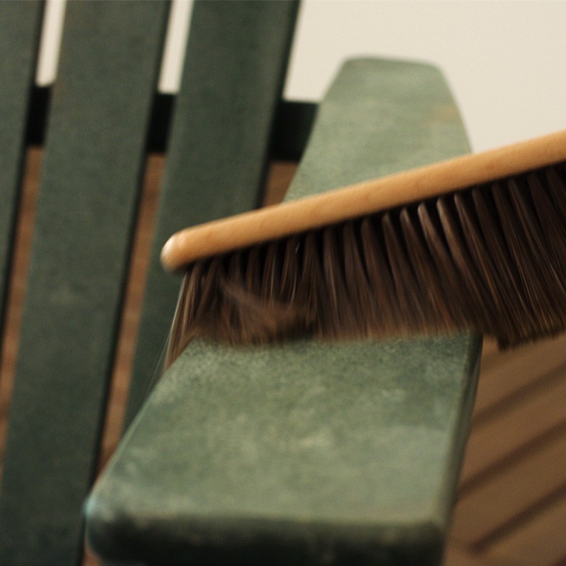 Close-up of a brush on an adirondack chair arm.