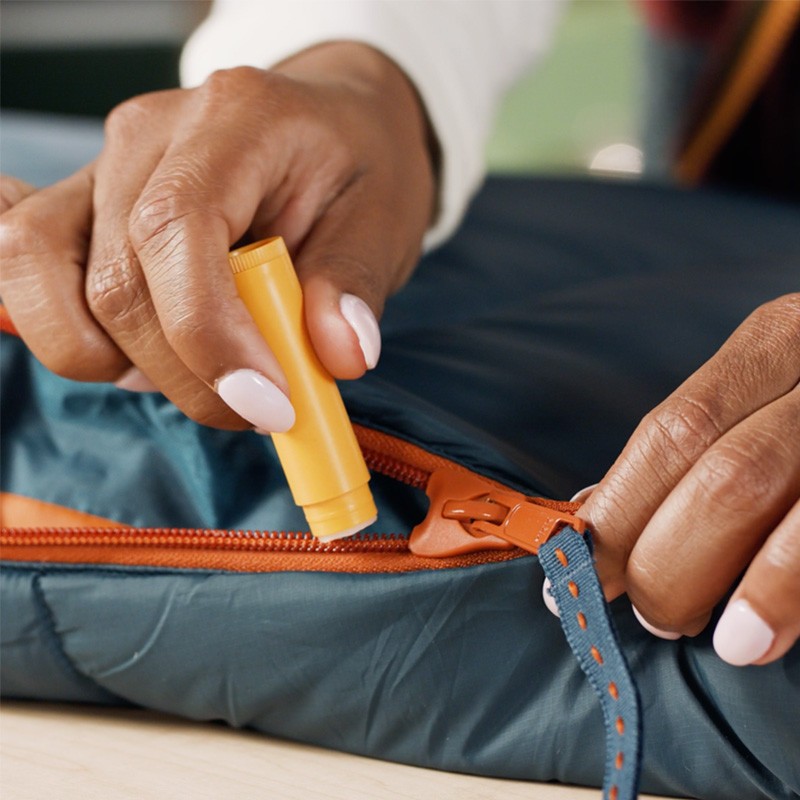 Stephanie applying chapstick to a zipper.