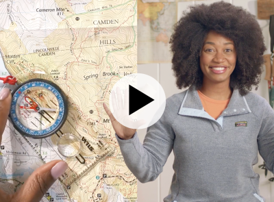 A map and compass on the left, and Stephanie on the right, a play video icon in the center.